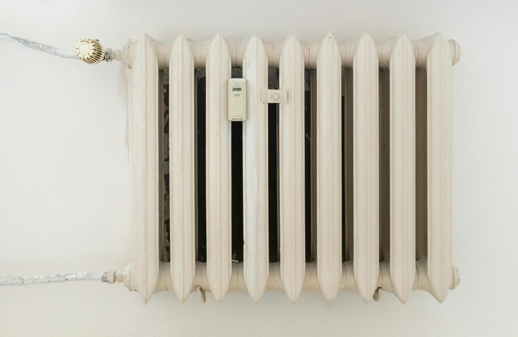 Weißer Metallheizkörper an einer schlichten Wand
