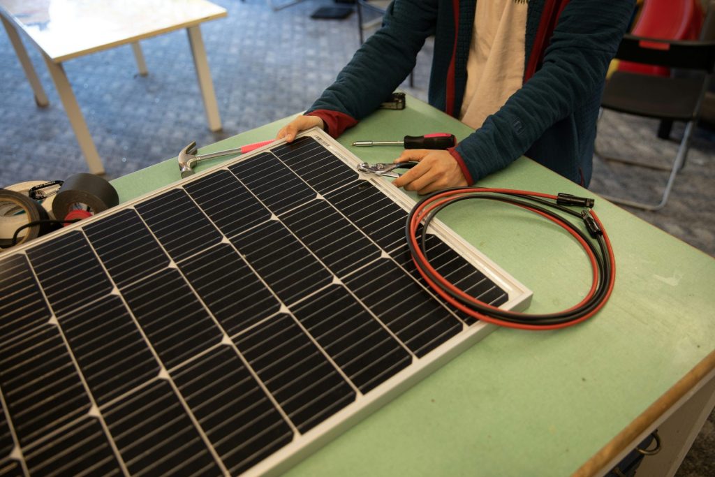 eine Person, die an einem Solarpanel auf einem Tisch arbeitet
